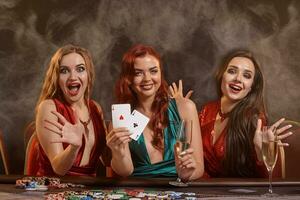 grupo do uma jovem rico senhoras estão jogando pôquer às uma casino. foto