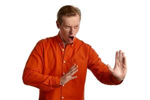 fechar-se retrato do uma gengibre cara dentro laranja camisa posando isolado em branco fundo. sincero emoções. foto