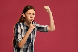 lindo Adolescência menina dentro uma casual xadrez camisa é posando contra uma Rosa estúdio fundo. foto