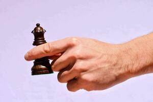 uma mão segurando uma xadrez peça foto