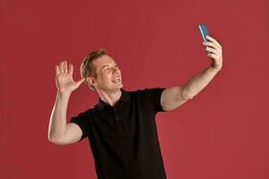 fechar-se retrato do uma gengibre cara dentro Preto camiseta posando em Rosa fundo. sincero emoções. foto