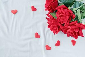 vermelho rosas com coração em forma confete em cama foto