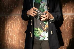 menina fotógrafo com a velho Câmera dentro dele mãos. foto