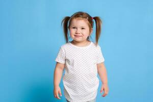 engraçado criança dentro branco camiseta em azul fundo. pequeno bonita menina isolado em azul fundo. cópia de espaço para texto. foto