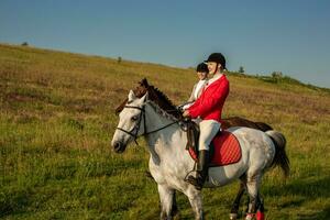 dois jovem mulheres equitação cavalo dentro parque. cavalo andar dentro verão foto