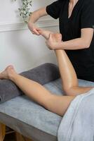 massageando os músculos cansados. close-up de massagista massageando bela perna feminina foto