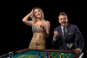 casal jogos de azar às roleta mesa dentro cassino foto