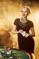 uma mulher dentro uma Preto vestir com cartões dentro dela mãos é em pé perto a pôquer mesa foto