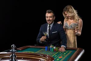 casal jogos de azar às roleta mesa dentro cassino foto