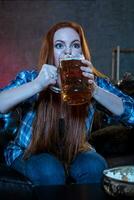 jovem mulher esporte ventilador assistindo Combine bebendo Cerveja foto