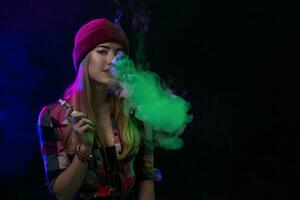 Cigarro eletrônico garota. jovem hipster mulher vape e-cig em Preto fundo. hip-hop estilo. estúdio tiro foto