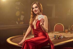 fechar-se tiro do uma lindo mulher posando contra uma pôquer mesa dentro luxo casino. foto