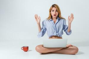 jovem mulher sentado em a chão e usando computador portátil foto