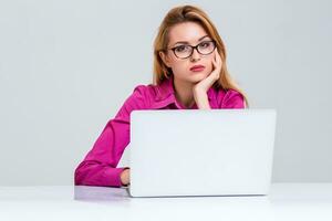 jovem mulher sentado dentro a mesa e usando computador portátil foto