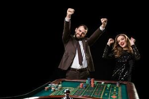 homem com mulher jogando roleta às a casino. vício para a foto