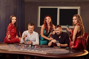 grupo do uma jovem rico amigos estão jogando pôquer dentro casino. foto