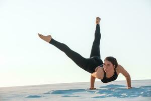 jovem profissional ginasta mulher dança ao ar livre - areia de praia foto