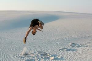 homem estude Parkour em seus ter. acrobacia dentro a areia foto