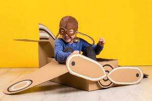 pequeno sonhador menina jogando com uma cartão avião. infância. fantasia, imaginação. foto