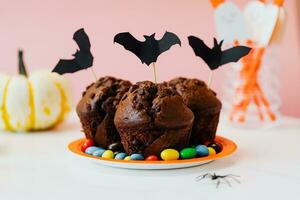 dia das Bruxas chocolate bolos com morcegos e doces em branco fundo foto