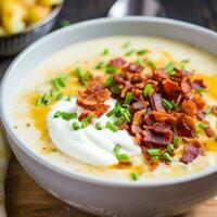 ai gerado uma cremoso e reconfortante batata sopa com bits do crocantes bacon e uma montão do azedo creme em topo foto