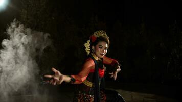 uma javanese dançarino vestido dentro tradicional vermelho roupas encantado a público com dela gracioso movimentos este misturado com a melodia foto