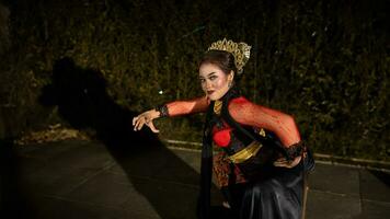 uma javanese dançarino faz flexível e fluindo movimentos dentro Tempo com a ritmo do a música foto