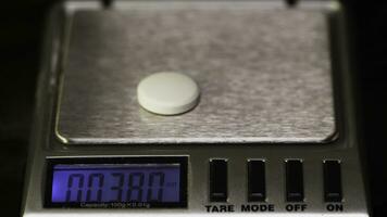farmacêutico, pesa a fabricado comprimidos em a ao controle escalas. dieta pílulas em uma escala. peso perda remédio derramado foto