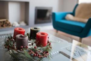 decoração de natal nas cores verdes e vermelhas. coroa do advento com velas coloridas. sala de estar moderna com fogão. Madri, Espanha foto