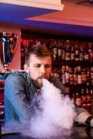 vapor. Cigarro eletrônico homem dentro uma nuvem do vapor. foto é ocupado dentro uma vape bar.