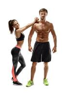 esporte, fitness, exercite-se conceito. em forma casal, Forte muscular homem e fino mulher posando em uma branco fundo foto