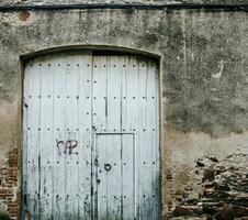 velho fechadas tecido porta com ferro acessórios. medieval de madeira porta dentro uma pedra muro. t foto