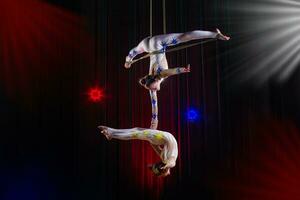 circo atriz acrobata desempenho. dois meninas executar acrobático elementos dentro a ar. foto