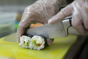 fechar acima do homem japonês restaurante chefe de cozinha cozinhando Sushi dentro a cozinha foto