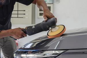 detalhamento de carro - mecânico masculino segurando a máquina de polir de carro. indústria automobilística, polimento de automóveis e oficina de pintura e reparação. foto