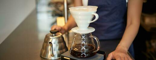 fechar acima do filtro café fermentação kit e chaleira, cafeteria barista preparando filtro às a contador foto