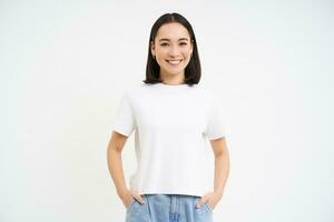 retrato do jovem confiante ásia mulher, parece com confiança carrinhos dentro casual camiseta, isolado em branco fundo foto