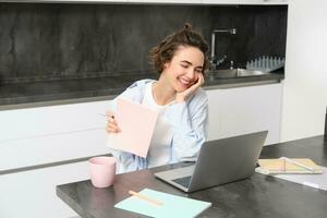 retrato do jovem profissional mulher, trabalho a partir de lar, parece às computador portátil, estudos on-line, conecta para uma webinário, trabalhos controlo remoto encontro através da computador, vídeo chats com tutor a partir de cursos local na rede Internet foto