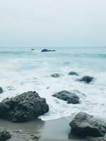 ai gerado oceano ondas em a de praia com alguns pedras foto