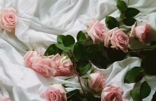 ai gerado Rosa rosas estão queda em uma branco pano com verde folhas foto
