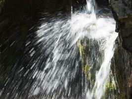 uma pessoa em pé dentro frente do uma cascata foto