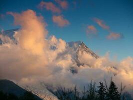 uma montanha coberto dentro nuvens com uma azul céu foto