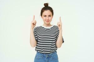 estilo de vida e propaganda conceito. jovem sorridente mulher, moderno garota, apontando dedo às promoção, mostrando bandeira, Lugar, colocar com texto, isolado em branco fundo foto