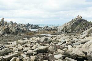 oceano costa com pedras do colunar basalto, capa estúpido em kunashir ilha foto