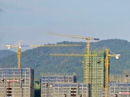 torre guindaste operativo às desenvolvimento site, cidade, guindaste e construção com apartamento edifícios, propriedade desenvolvimento, a infraestrutura, urbano paisagem, Civil Engenharia, cassino edifícios dentro Laos foto