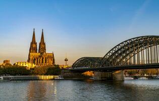 Colônia catedral e Hohenzollern ponte iluminado de a manhã Sol foto