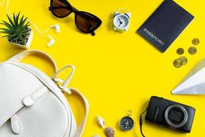 conjunto de acessórios elegantes para as suas férias de verão. viagens de verão. passaporte, óculos escuros, mochila e dinheiro em fundo amarelo.