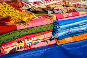 indiano tecidos em a mercado, tecidos, colchas e roupas a partir de Índia foto