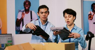 diverso loja gerentes preparando pacotes para envio, colocando à moda roupas dentro cartão caixas dentro moderno boutique. empregados trabalhando às clientes ordens, discutindo Entrega detalhes dentro compras Shopping foto