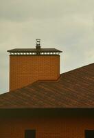 a casa está equipada com coberturas de alta qualidade de telhas de betume de telhas. um bom exemplo de cobertura perfeita. o telhado é protegido de forma confiável contra condições climáticas adversas foto